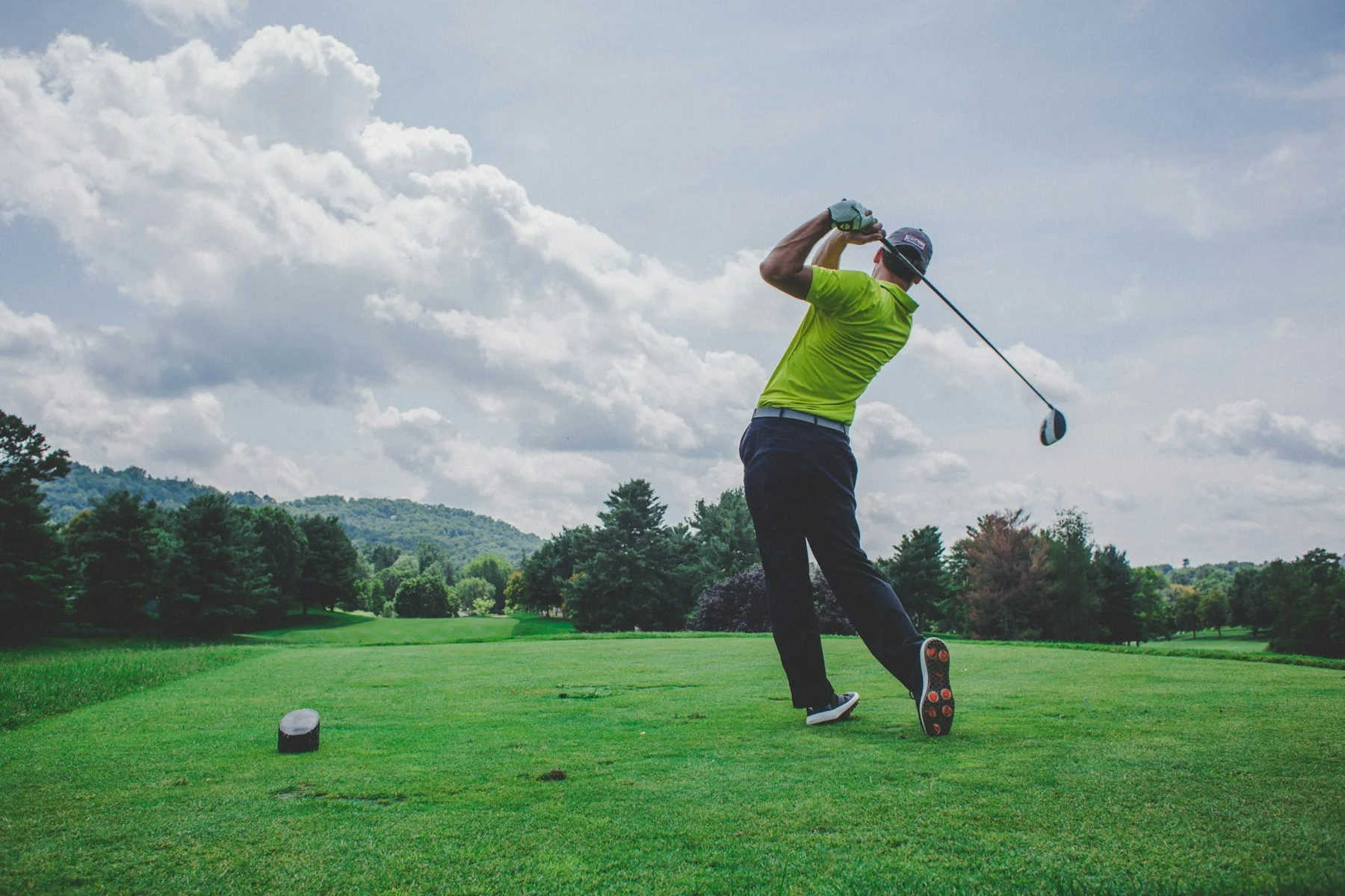 An amateur golfer swinging a driver on a course