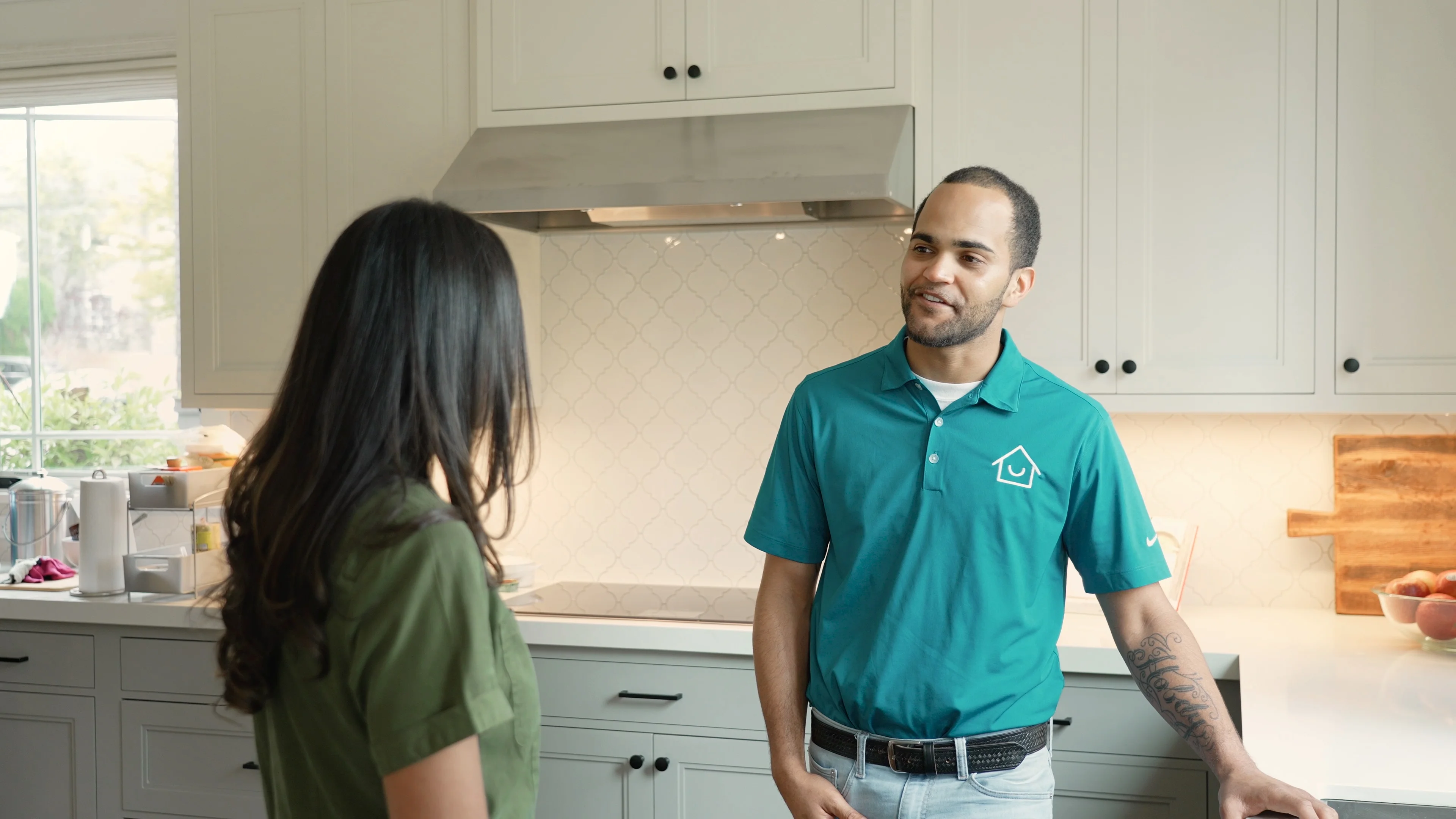 Honey Homes handyman talking with a homeowner in her kitchen